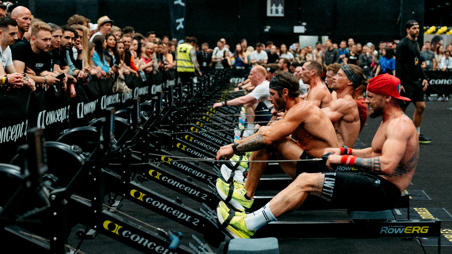 Athletes training on rowing machines at a HYROX event